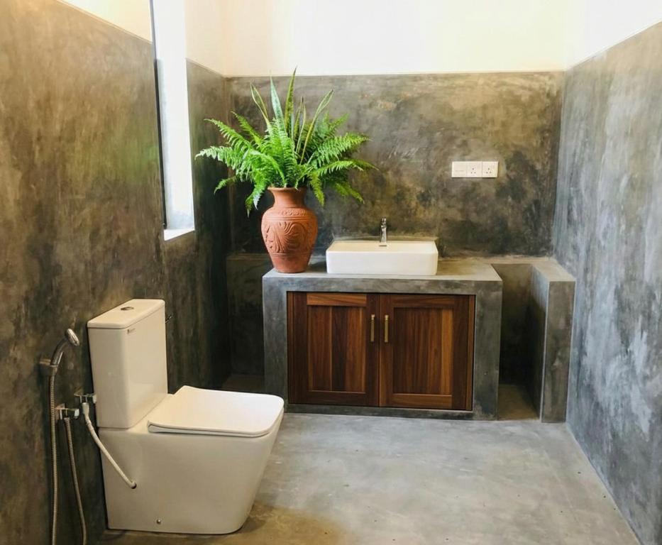 a bathroom with a toilet and a sink at Yohan Eco Lodge Udawalawe in Udawalawe