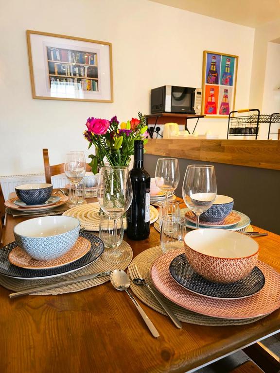 a wooden table with plates and bowls and wine glasses at The Wigtown Ploughman in Wigtown
