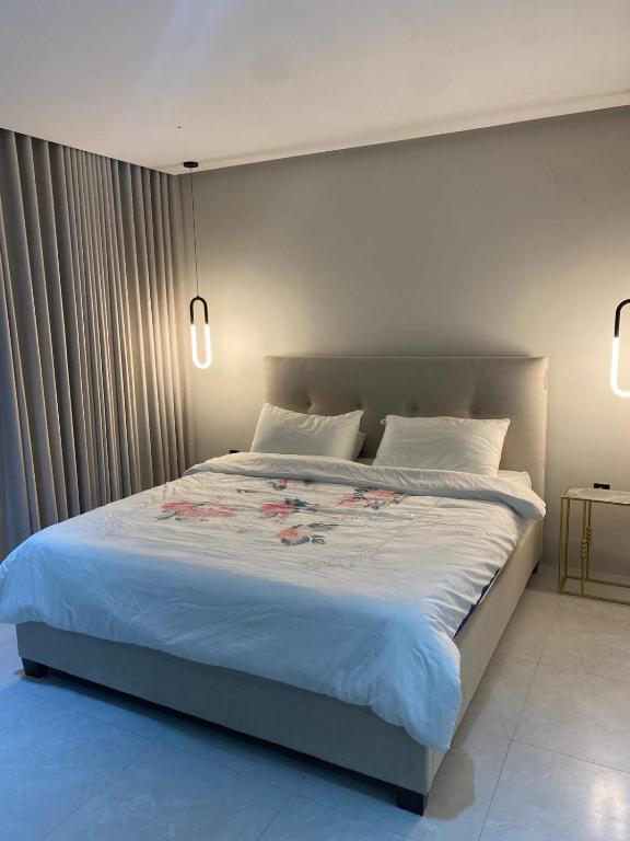 a bedroom with a large bed with white sheets at Doha studio in Al Wakrah