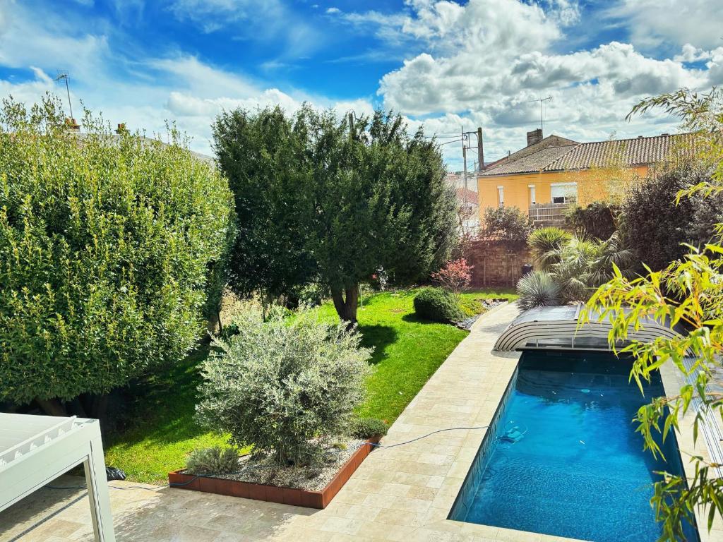 een tuin met een zwembad en bomen bij Villa Merma in Luçon