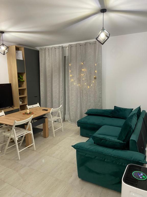 a living room with a green couch and a table at Apartament Bonton Predeal in Predeal