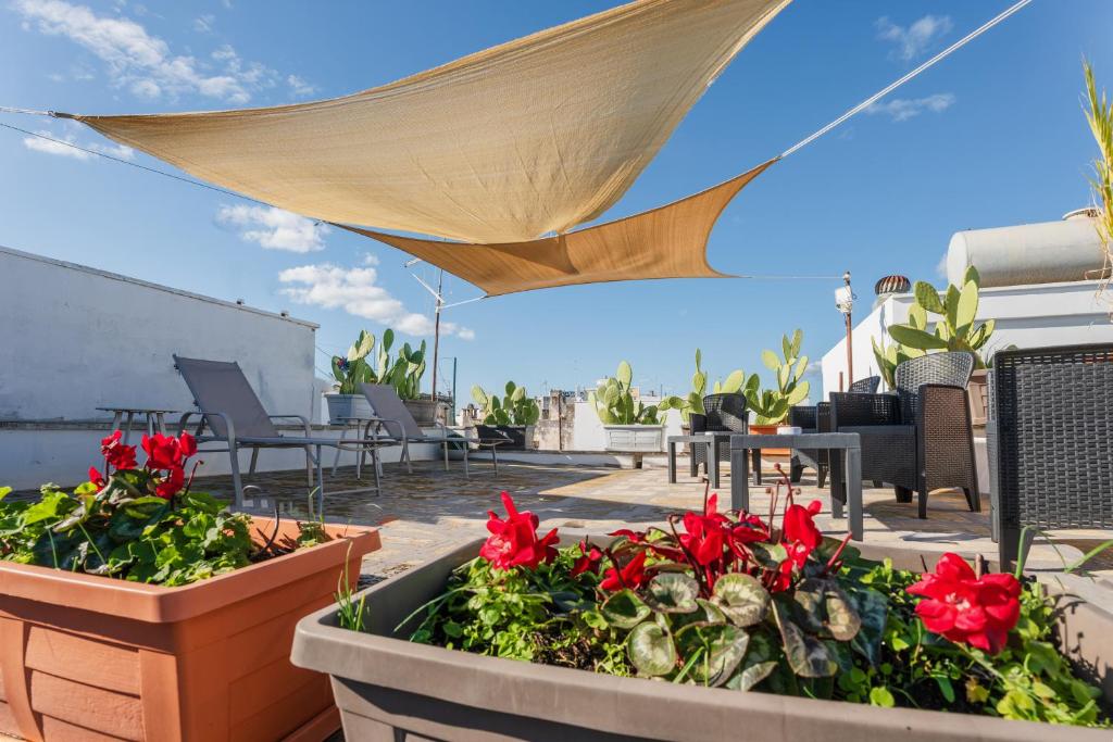 卡洛维诺BED&BREAD Piazza 'Nzegna的屋顶上摆放着盆栽花卉的露台