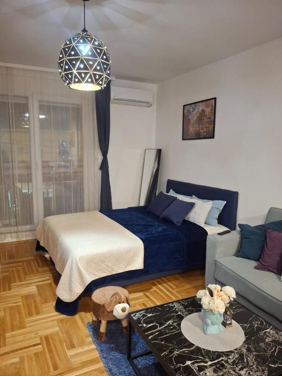 a bedroom with a bed and a couch at Studio Apartman Taurus in Požarevac