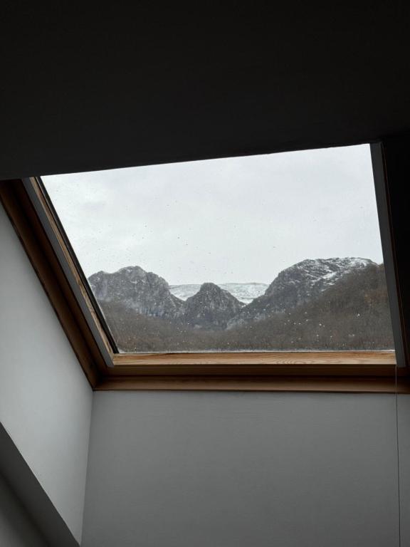 a window in a room with a mountain view at Ático luminoso en Felechosa in Felechosa