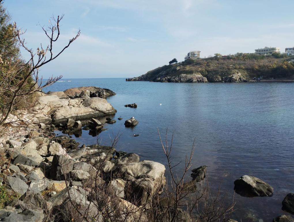 a large body of water with rocks and an island at Paradise in Burgas City