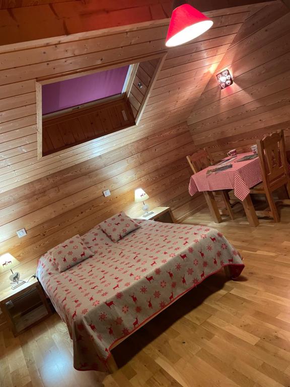 une chambre avec un lit dans une cabane en bois dans l'établissement Au Solé, à Basse-sur-le-Rupt