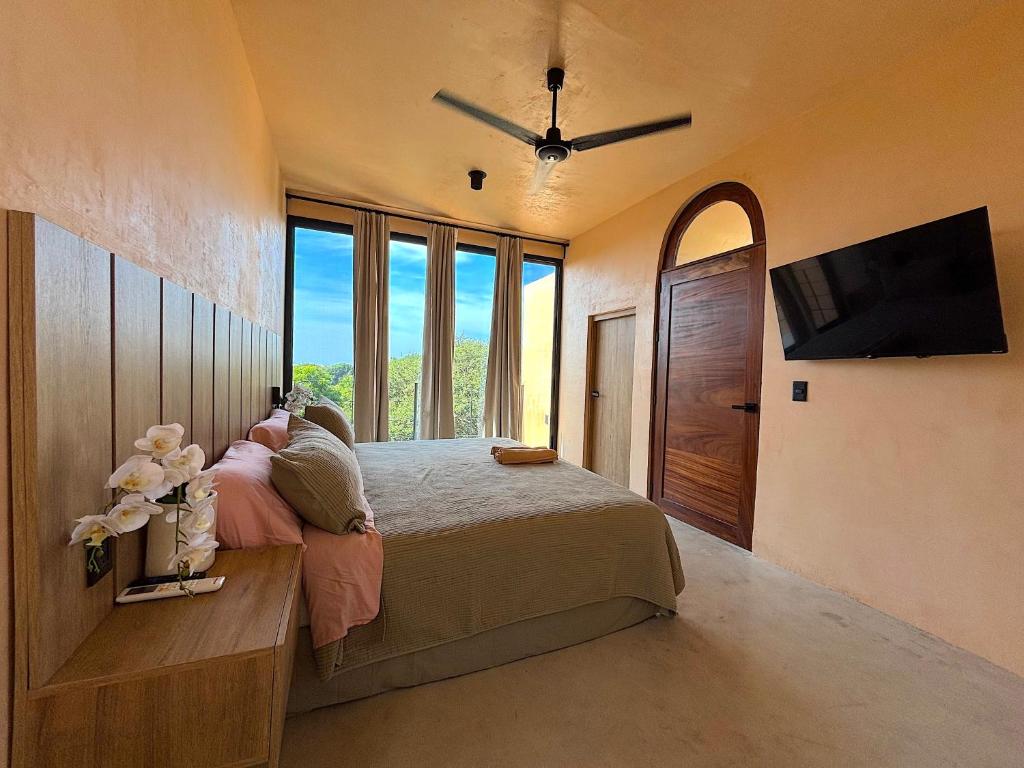 a bedroom with a bed and a flat screen tv at Casa Melon 1BR Spectacular Private Oceanview Terrace in Santa María Colotepec