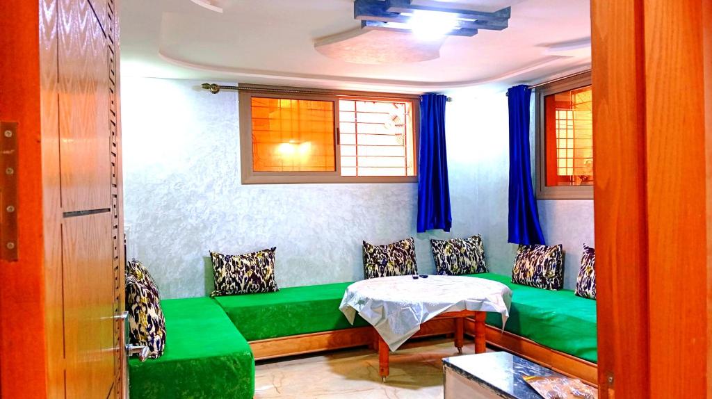 a room with a green bench and a table at Dar Bouchikhi in Moulay Yacoub