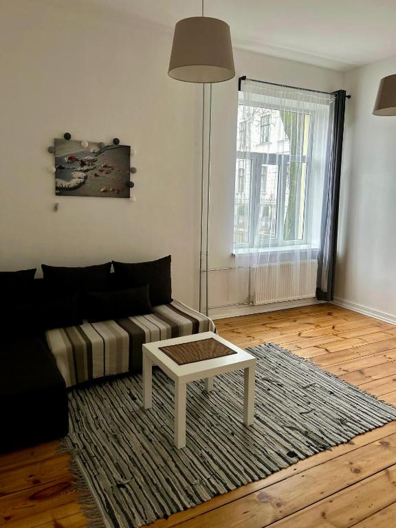 a living room with a couch and a coffee table at Spacious one bedroom Ausekļa apartment in Liepāja