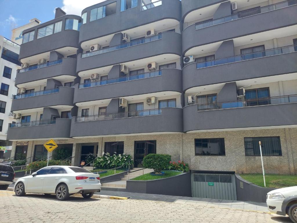 een witte auto geparkeerd voor een gebouw bij Apartamento 100metros do Mar 2 quartos in Bombinhas