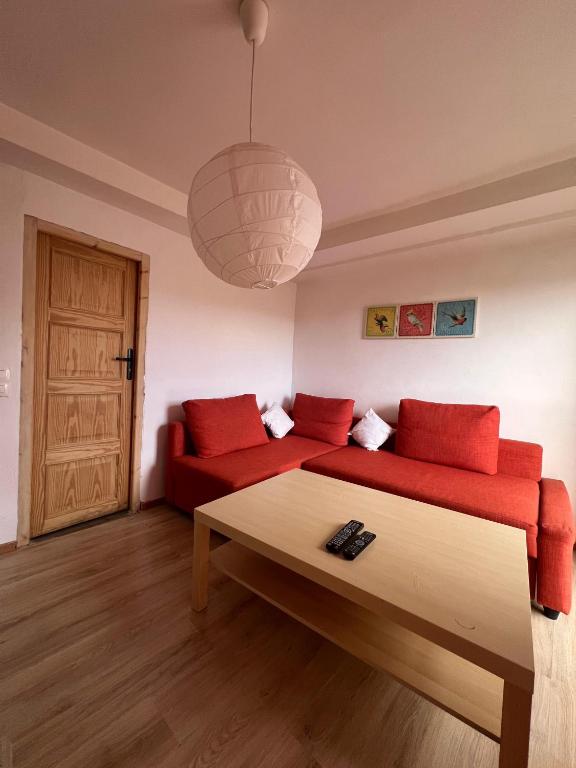 a living room with a red couch and a table at Appart Hôtel Signature in Taza