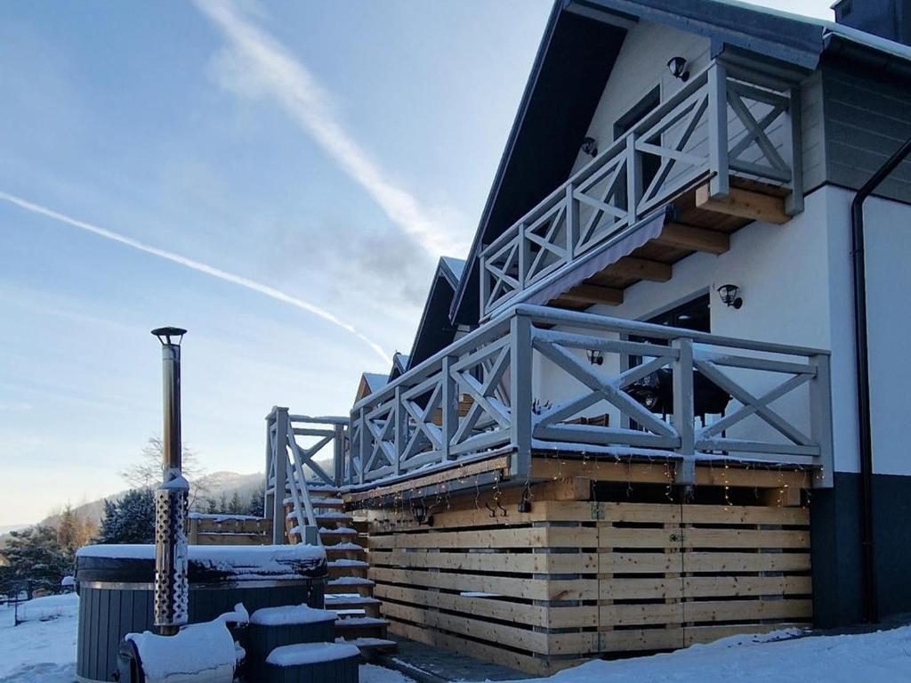 Un edificio con un balcón con nieve en el suelo. en Tu Jest Pięknie, en Ropa