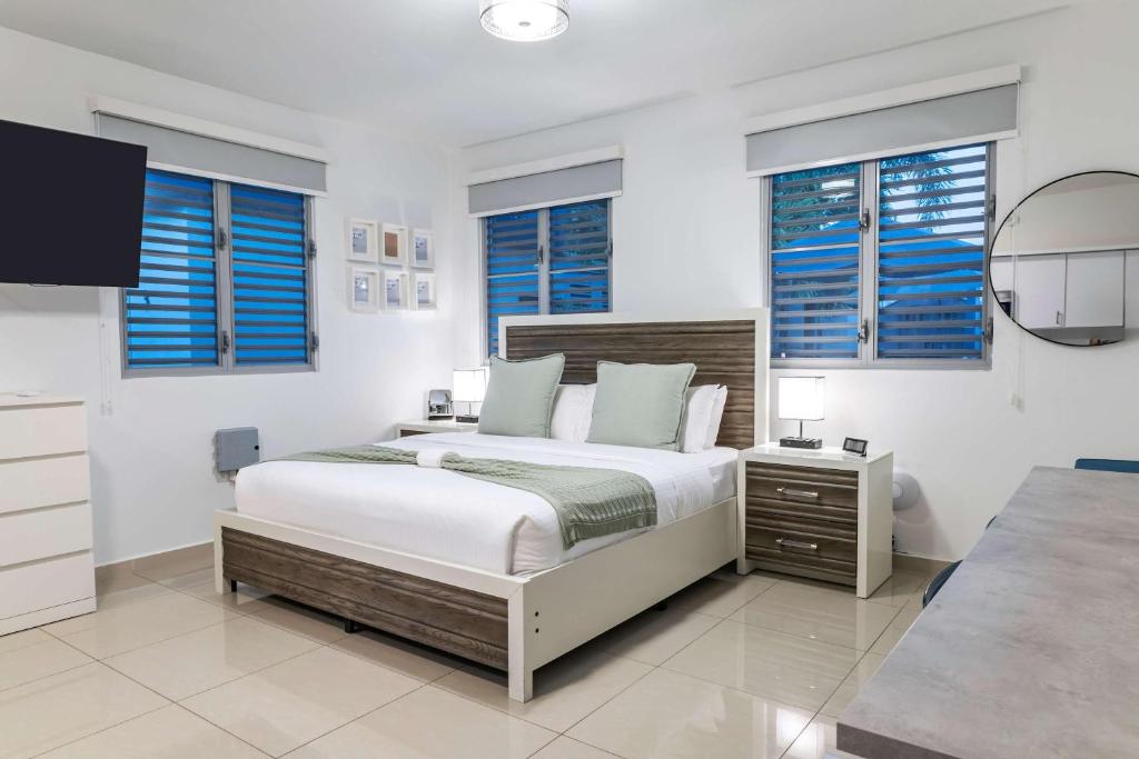 Un dormitorio blanco con una cama grande y ventanas en Aquaville Dorado Moderna Studio 6, en Dorado
