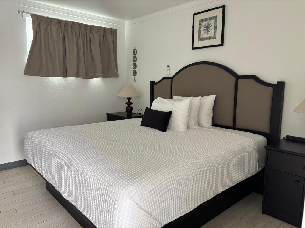 a bedroom with a bed with a black and white comforter at Holiday Isles Resort in St Pete Beach