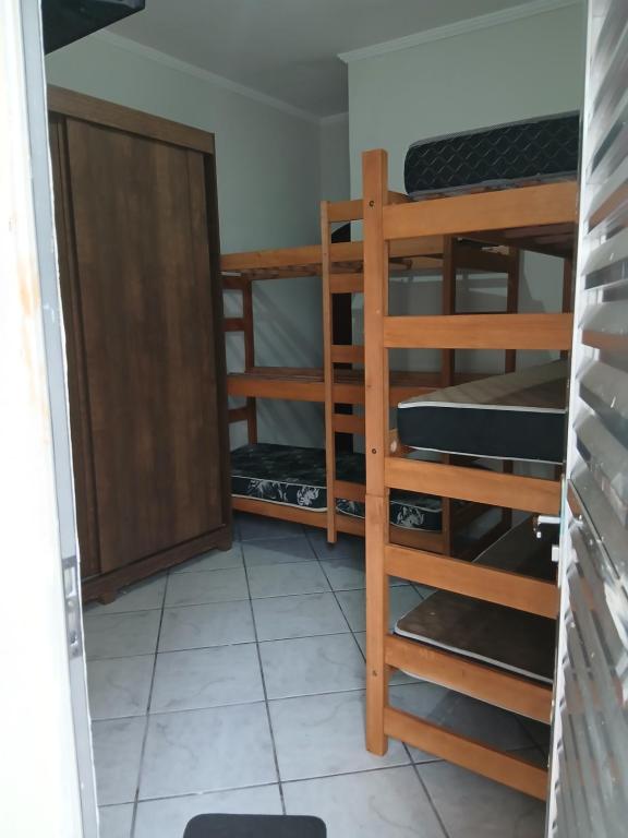 大普拉亚Casa pé na areia 40 metros da praia Caiçara的带三张双层床和一扇门的房间