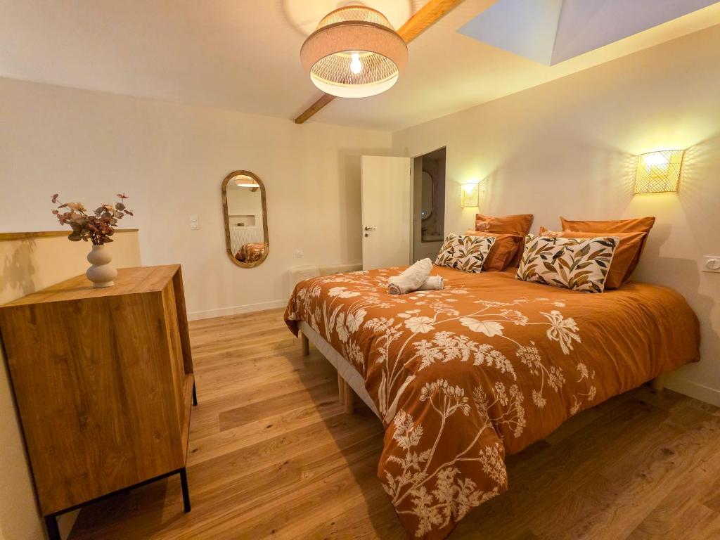 a bedroom with a large bed and a wooden floor at Cottage in Pontivy