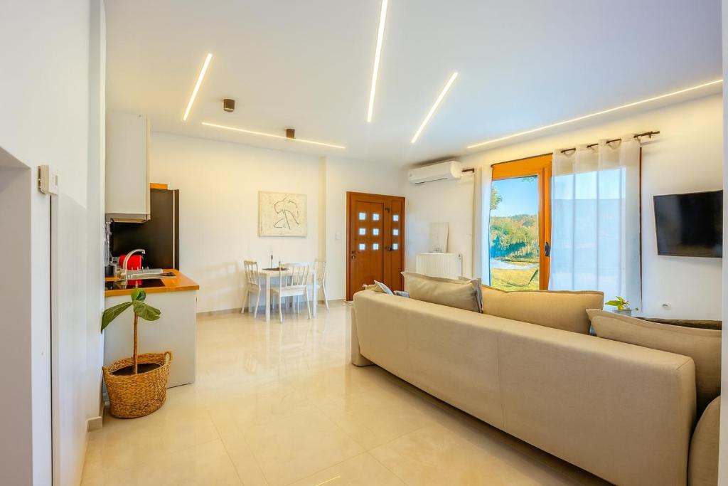 a living room with a couch and a kitchen at Oasis Acropolis Serres With Parking Next to Center in Serres