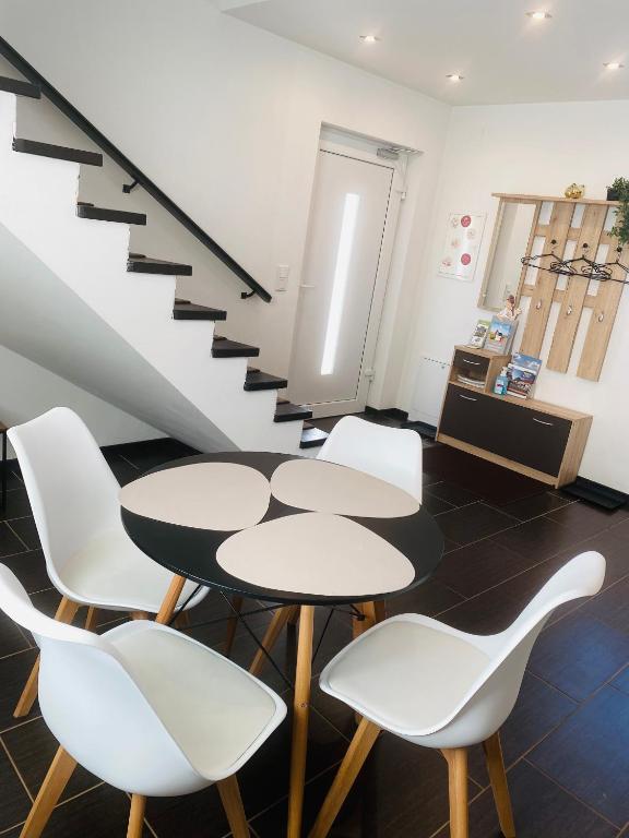a room with two tables and white chairs and a staircase at Ferienhaus David in Pinkafeld