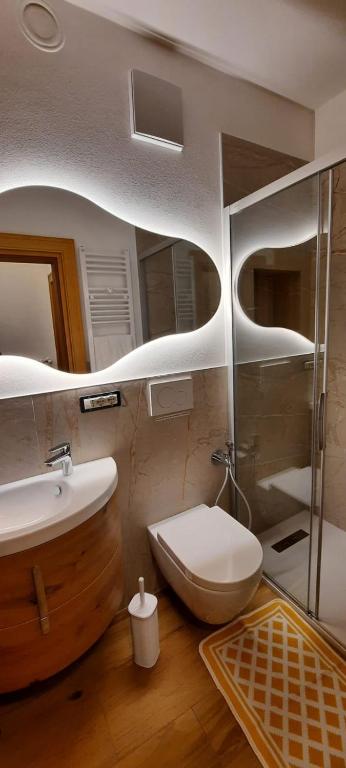 a bathroom with a toilet and a sink at Bella Cortina - comodo al centro e impianti, con garage in Cortina dʼAmpezzo