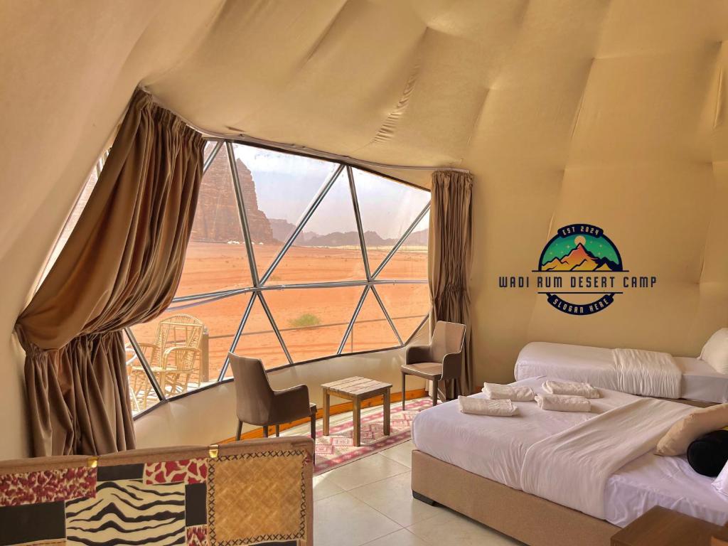 a bedroom with a bed and a large window at WADl RUM DESERT CAMP in Wadi Rum