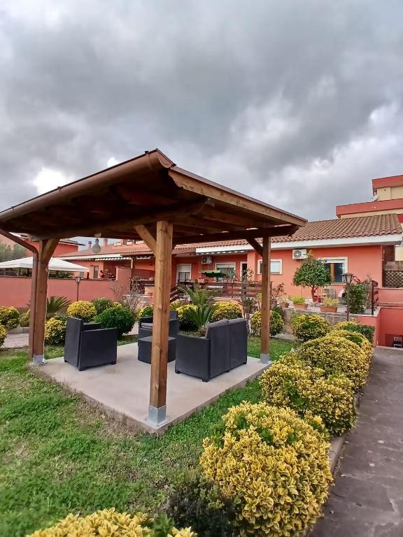 a wooden pavilion in a yard with bushes at Casa di Viaggiatori Ciampino in Ciampino