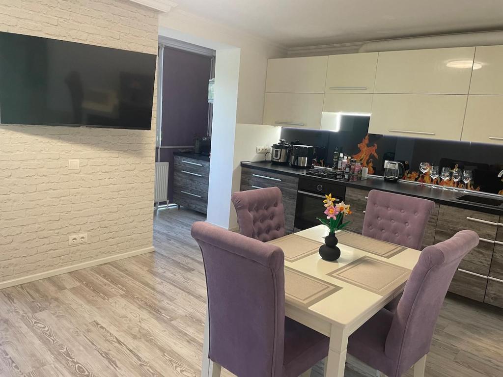 una cucina con un tavolo con sedie viola e una sala da pranzo di Spacious apartment with a beautiful view a Căuşeni