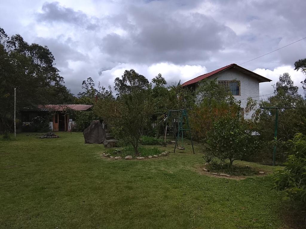 a yard with a playground and a house at Farmstay in Ibarra