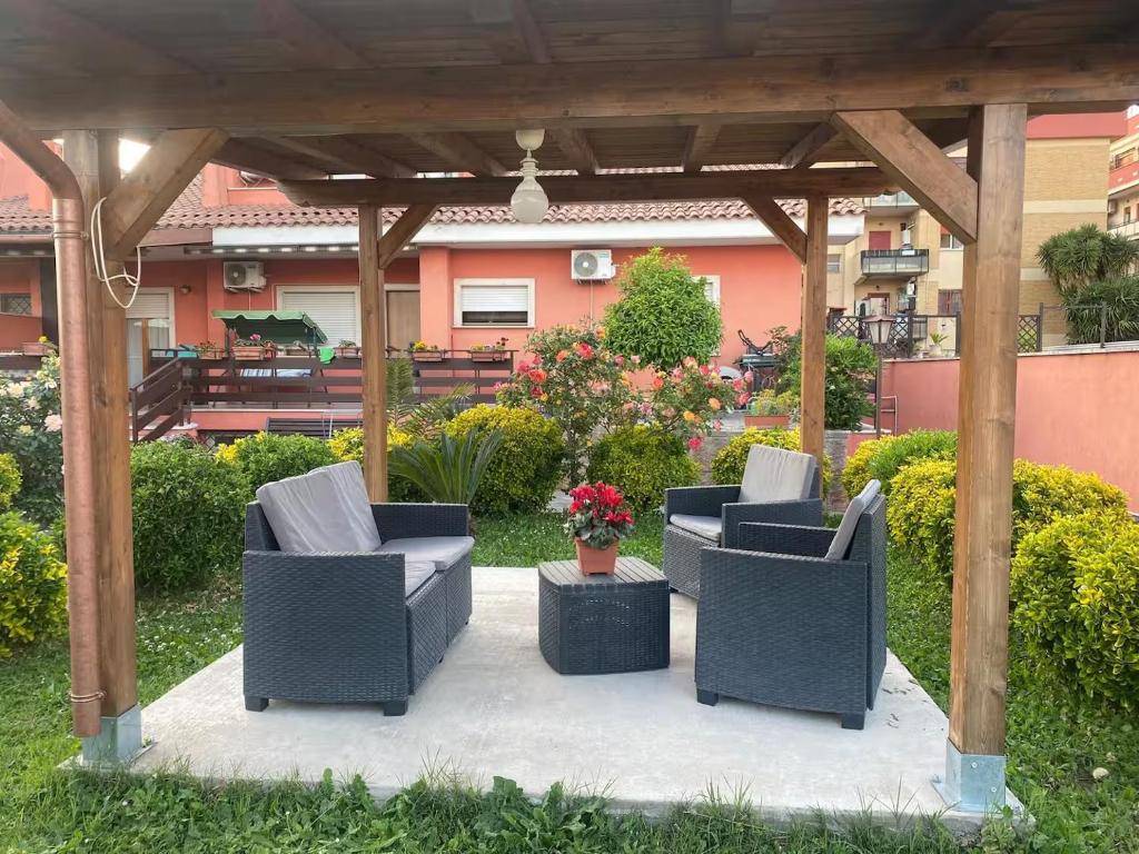 una pérgola con sillas y flores en un patio en Casa di Viaggiatori Ciampino, en Ciampino