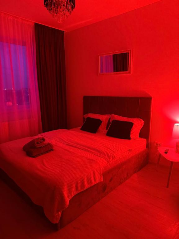 ein rotes Schlafzimmer mit einem großen Bett mit rotem Licht in der Unterkunft DreamStay Militari Residence in Roşu