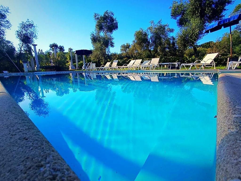 a large swimming pool with chairs and blue water at Villa Meridiana in Itri