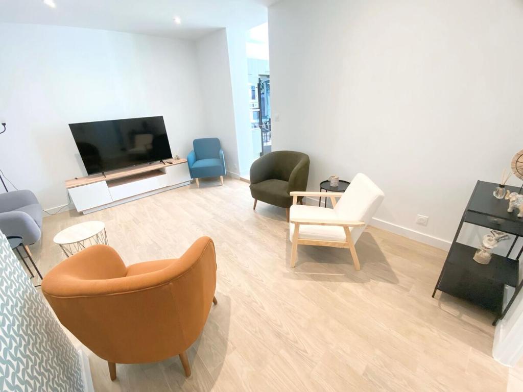 ein Wohnzimmer mit Stühlen und einem Flachbildfernseher in der Unterkunft Chambre privée -Pessac-Modern BR1-1 in Pessac
