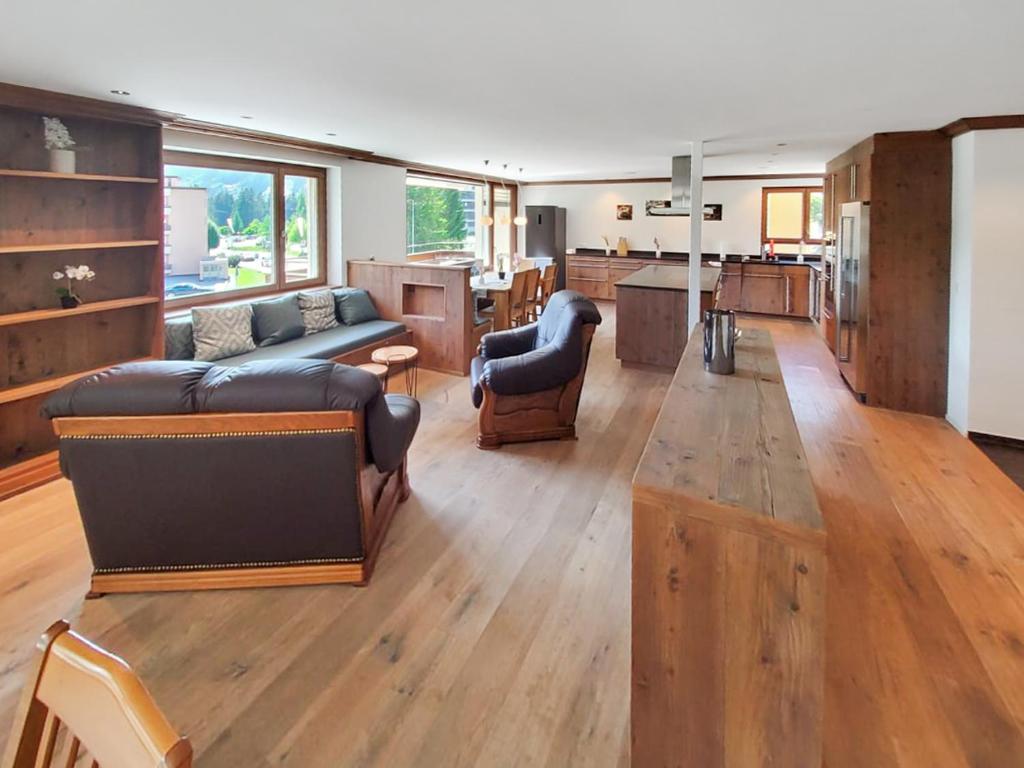 a large living room with a couch and a kitchen at Luxuriöses Penthouse in Davos modern hochwertig in Davos