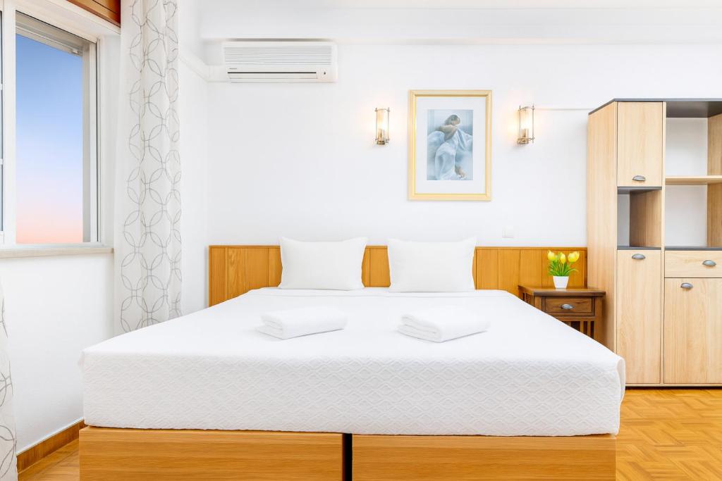 ein Schlafzimmer mit einem weißen Bett und einem Fenster in der Unterkunft Lagos Central Suite DBV Guesthouse in Lagos