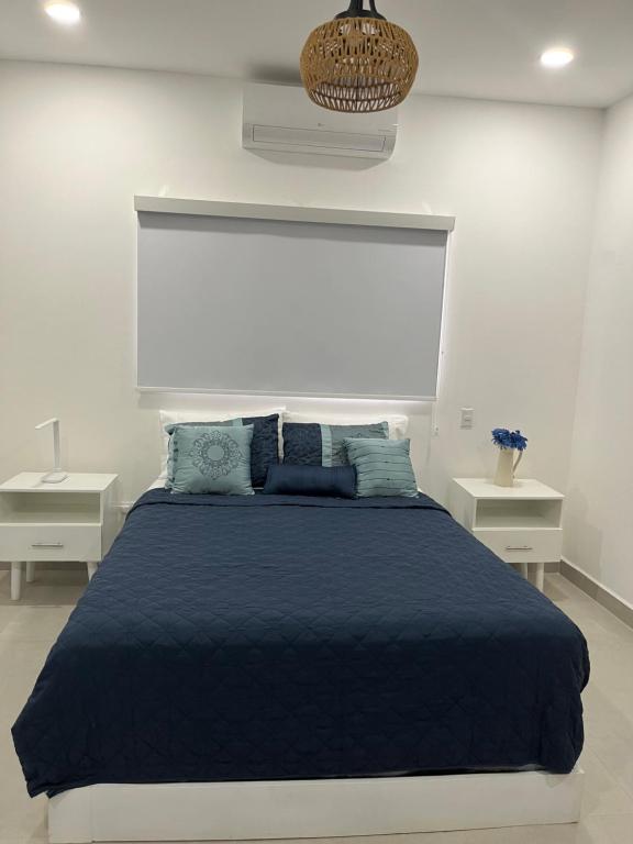 a bedroom with a blue bed with two night stands at Villa Karol in Rivas