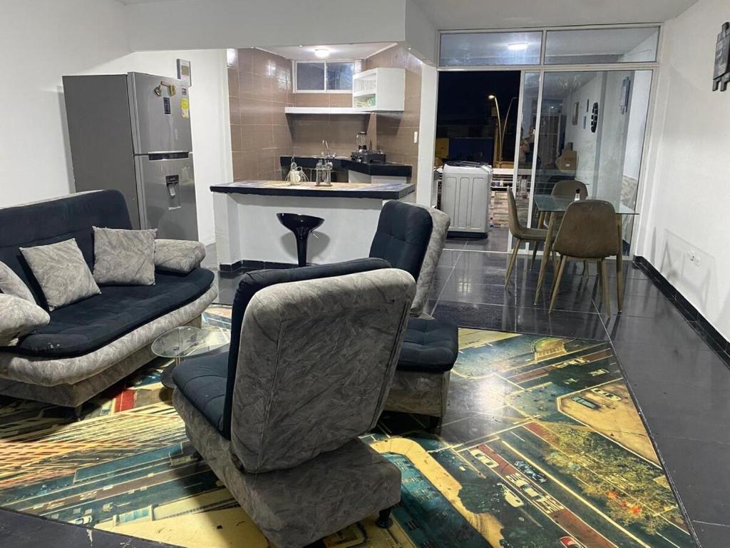 a living room with a couch and chairs and a kitchen at Apartamento Brisa Marina cómodo y accesible in Santa Marta