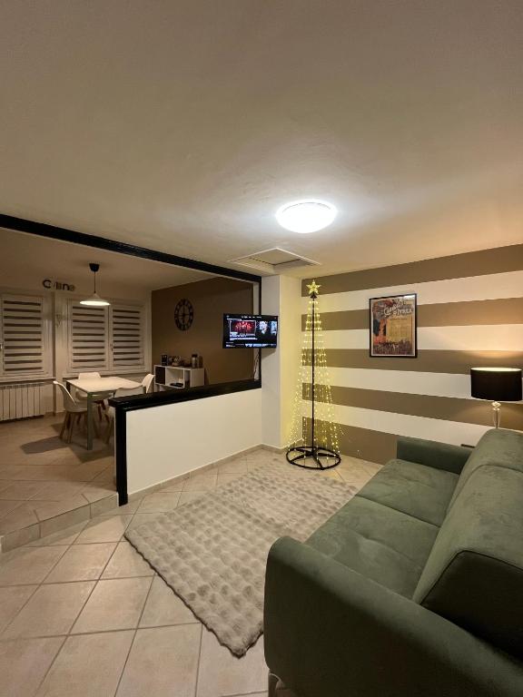 Una sala de estar con un sofá y un televisor en una pared. en Eporedia Inn, en Ivrea