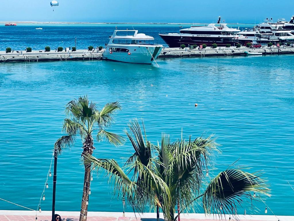 twee boten liggen aangemeerd in een haven met palmbomen bij Marina Suite in Hurghada