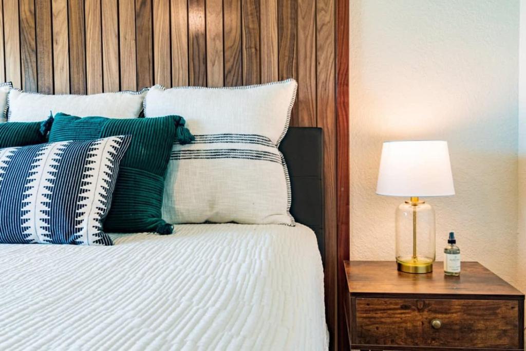 een bed met blauwe en witte kussens en een tafel met een lamp bij 400 South - Unit E in Cocoa Beach