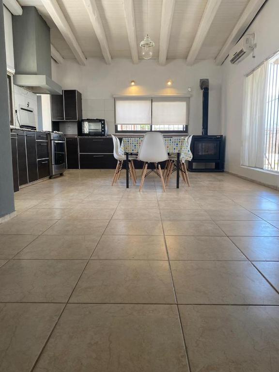 a large kitchen with a table and chairs on a tile floor at summer house in La Porteña
