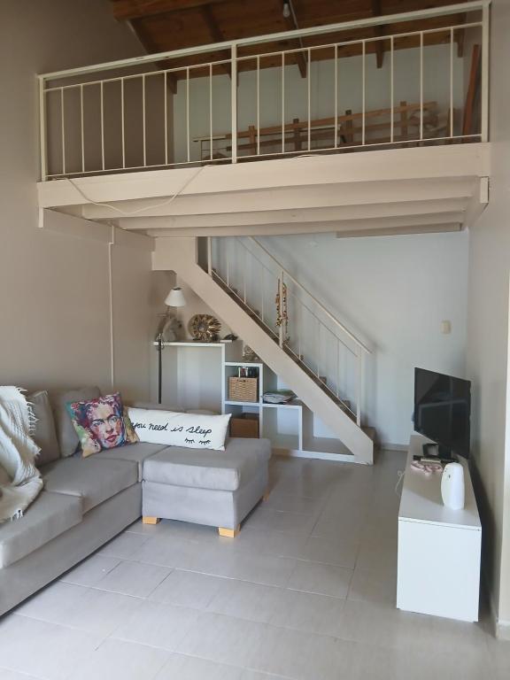 特雷利乌Espacios únicos en una amplia casa a metros de una laguna natural的带沙发和楼梯的客厅