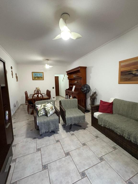 a living room with a couch and chairs and a piano at Enseada Malibu perto da praia, lazer e conforto! in Guarujá