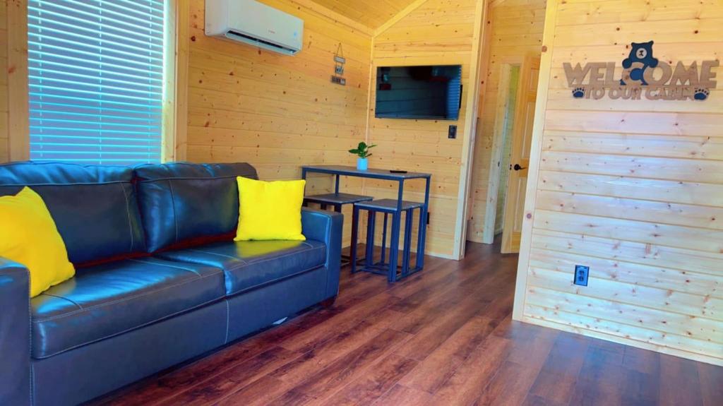 un soggiorno con un divano blu e un tavolo di Bryan North College Station KOA Holiday a Bryan