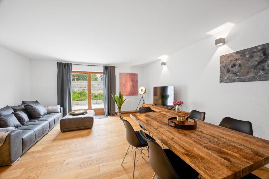 ein Wohnzimmer mit einem Holztisch und einer Couch in der Unterkunft Moderne Ferienwohnung mit Bergblick und großer Terrasse nahe Simssee, Chiemsee und Autobahn A8 Salzburg - München in Rohrdorf