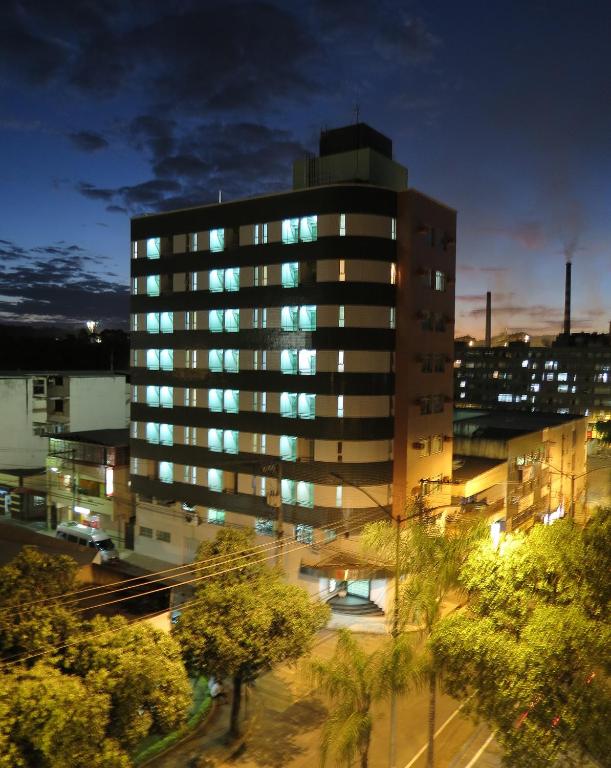 a tall building with blue lights in a city at Steel Valley Hotel in Ipatinga