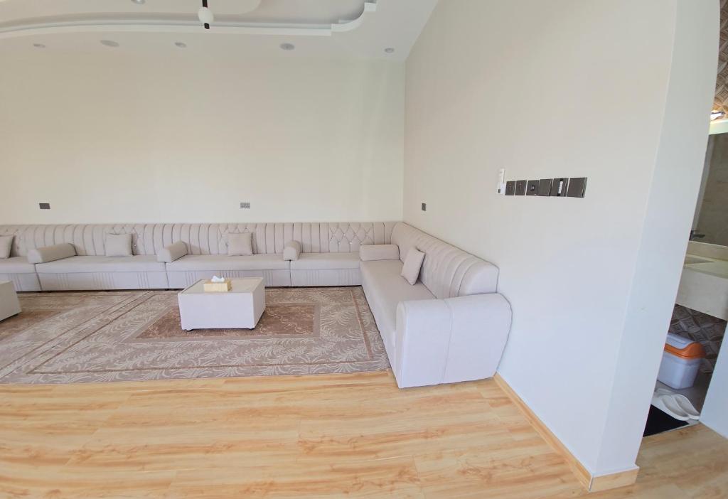 un soggiorno con un divano bianco e un tavolo di Algharam resort a Ḩaḑīb