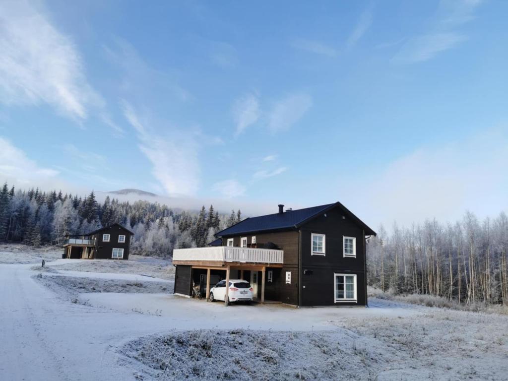 a house with a car parked in the snow at Trysil Central Villa in Trysil
