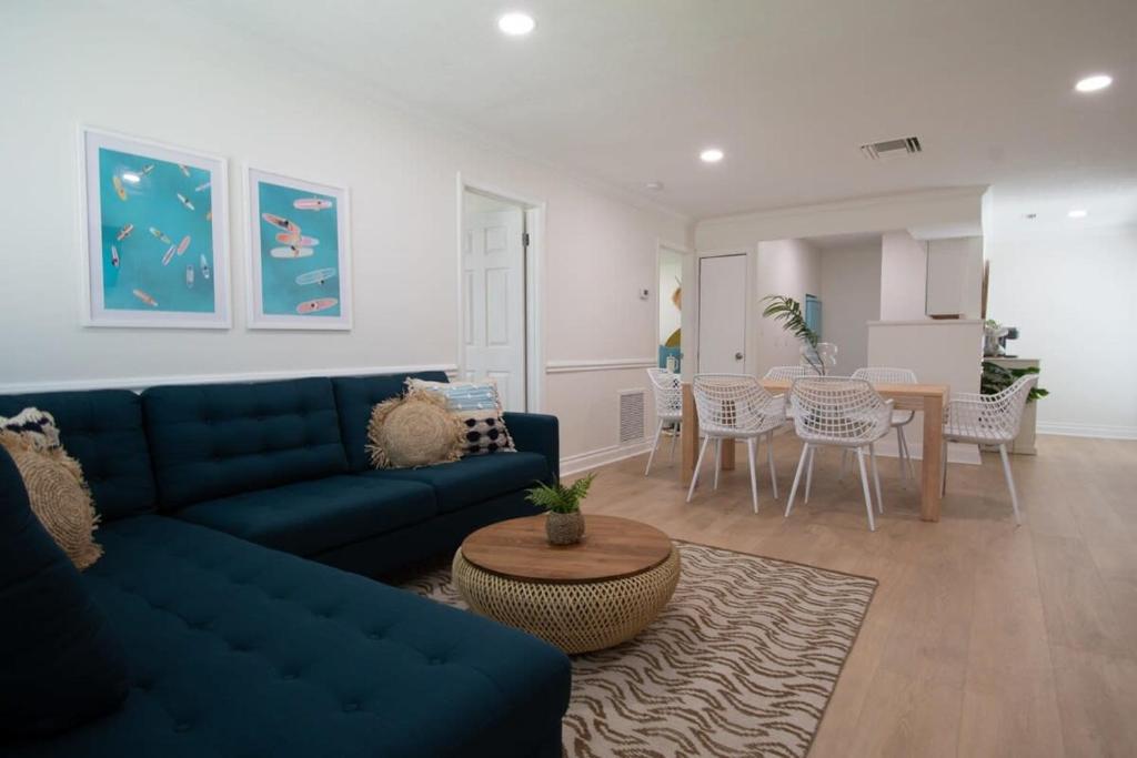 a living room with a blue couch and a table at The Juni-7 Unit Renovated Complex in Cocoa Beach