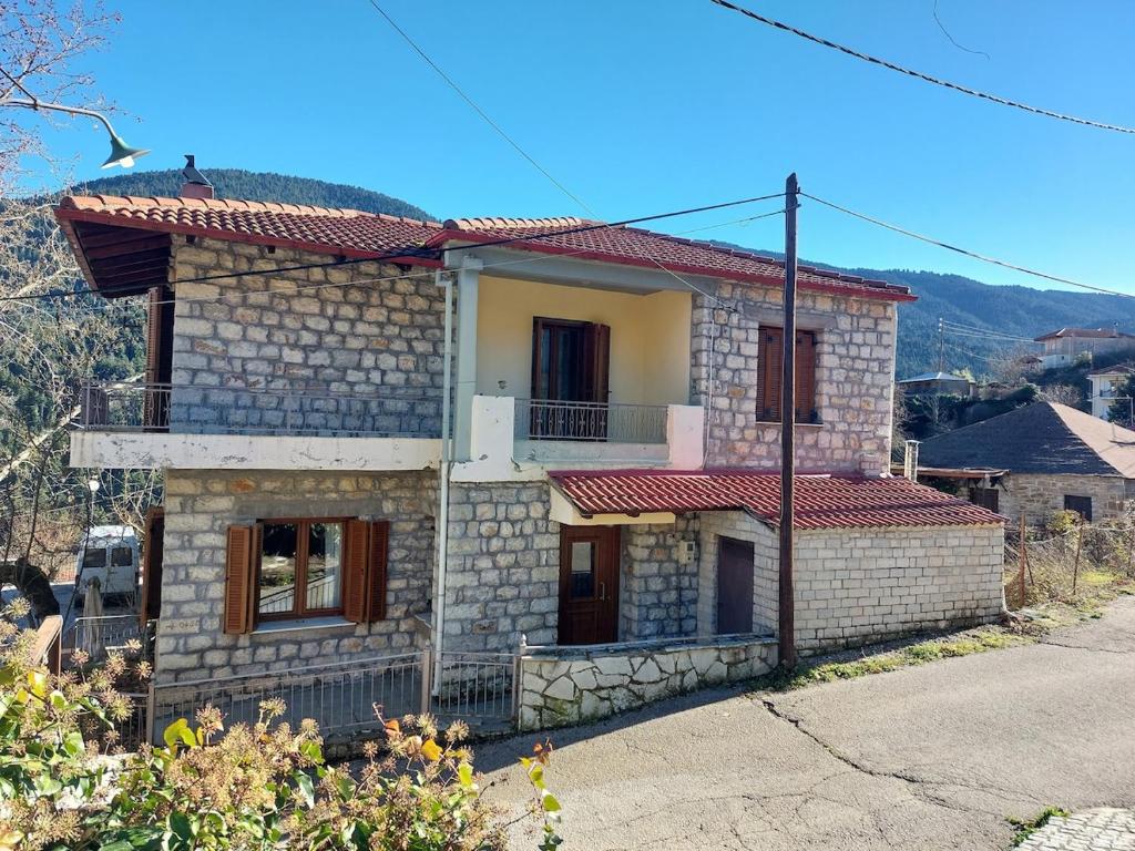 a stone house with a red roof at Gouvas stone house in Karpenisi