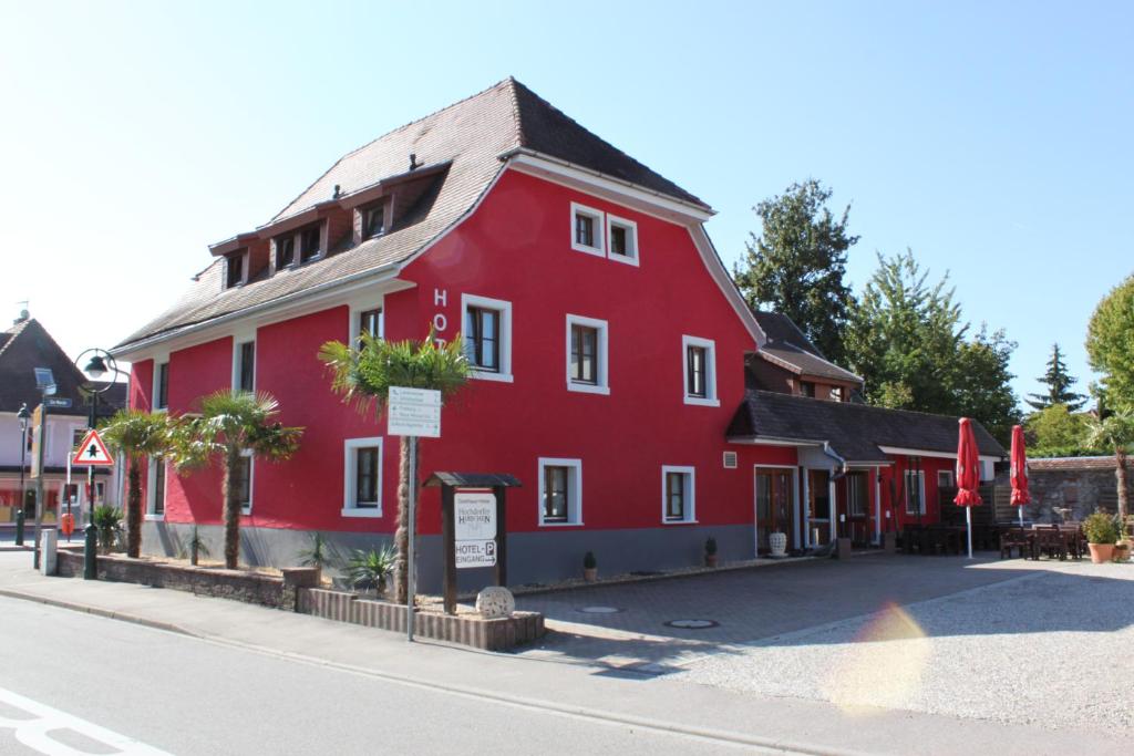 ein rotes Gebäude auf der Straßenseite in der Unterkunft Hotel Restaurant Hochdorfer Hirschen in Freiburg im Breisgau