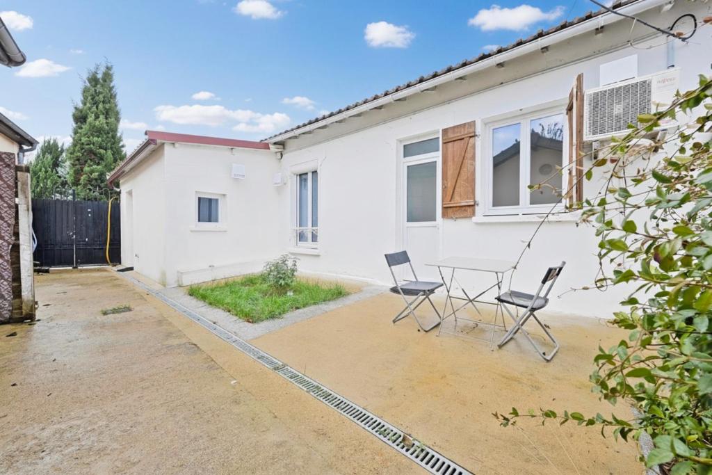 una casa con tavolo e sedie nel cortile di Gîte de Chalandray a Brunoy